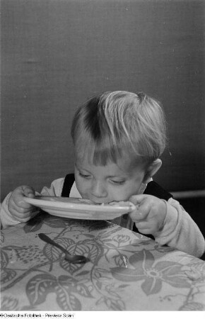 Ein Kind beim Verzehr von Nudelsuppe