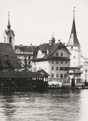 Luzern. Schweiz. Blick über die Reuss auf die Altstadt. Links der Turm der Turm der St. Peterskapelle; rechts das 1510 errichtete Haus Zur-Gilgen mit Turm. Im Vordergrund die Kapellbrücke