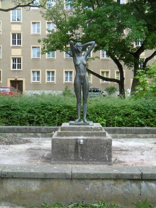 Eisenhüttenstadt: Wohnbebauung Brunnenring (WK I) mit Brunnen (Mädchenfigur)