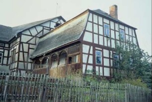 Teilansicht eines Fachwerkhauses mit Walmdach und Laubengang