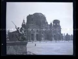 Blick auf den beschädigten Berliner Dom vom Alten Museum aus, im Vordergrund der "Löwenkämpfer" von Albert Wolff auf der linken Mauer der Freitreppe