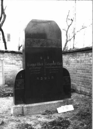 Grabstein 10 (Index: 99608895) Material: polierter Granit auf Granit Zustand: sehr gut Maße HxBxT: 192x115x24 cm Beschreibung: Stele mit Wangen, Sockel, gekappter, giebelartiger Abschluss Symbolik: florale Motive in Jugendstil Besonderheit: Doppelgrab: Grabstein 10