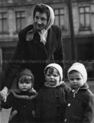Alte Frau mit drei Kindern