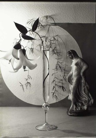 "Blumen um uns" (Photographische Plaudereien in Wort und Bild). Stilleben mit Lilienzweig in Glasvase und Keramikfigur (Schreitendes Mädchen)
