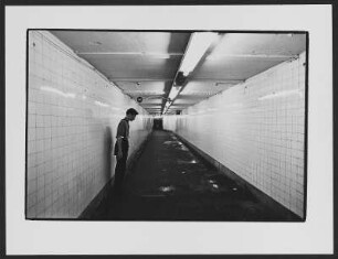 U-Bahnstation : Junger Mann im braunen Hemd der Hitlerjugend in einem Tunnel der New Yorker U-Bahn, vor einer gekachelten Wand stehend