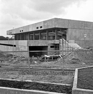 Sporthalle: Schulzentrum Glinde: Oher Weg: Rohbau: vorn Bauzaun: dahinter Sand- und Erdhaufen und Baumaterial