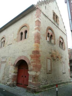 Stadtbild-Romanisches Steinhaus (1187-Vogtei 1984-renoviert)- Ansicht querab von Straße mit Eckquaderung sowie renovierten Biforien im Obergeschoß und Treppengiebel