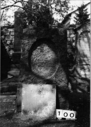 Grabstein 100 (Index: 99629601) Material: Granit Zustand: Platte fehlt Maße HxBxT: 106x59x35 cm Beschreibung: grob stelenhaft behauener Stein mit ovaler Schriftplatte: Grabstein 100 (1)