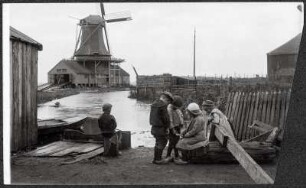 Blick auf eine Sägemühle an einem Kanal mit spielenden Kindern
