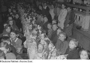 Kinder an gedeckten Tischen bei der Weihnachtsfeier des VEB Bodenbearbeitungsgeräte