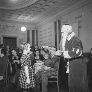 Ein Mädchen steht vor dem Weihnachtsmann, Kinderfest zur Weihnachtszeit