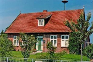 Oetjendorf: Oetjendorfer Landstraße 57: traufständiges Wohnhaus aus Backstein: Straßenfront mit Eingangstür, Rankgitter, Schleppgaube, Giebelpfahl, auf Dach Sirene: Vorgarten, vorne Gartenzaun
