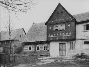Sohland an der Spree-Wehrsdorf. Umgebindehaus, ehemals Nummer 49 (1780). Eingangsseite (Teilansicht) mit Giebel des Wohnstallhauses, Dresdner Straße 51 (Nr. 48)