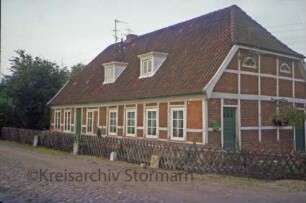 Lohbrügger Straße 16: Fachwerkkate: traufständige Straßenfront mit Eingangstür: rechts Giebelseite mit Tür