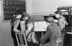 Musikinstrumentenbau Klingenthal : Schüler um einen Lehrer während des Musikunterrichts