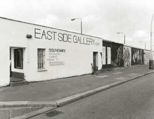 Berliner Mauer (East side gallery). Ehemailge Grenzübergangsstelle Mühlenstraße. Souvenir-Laden und Graffiti (1990)