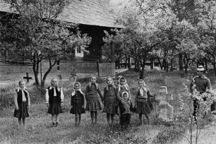 Mädchen und ein älterer Junge auf einem Friedhof