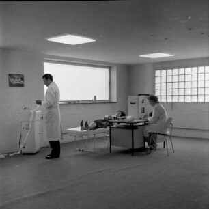Medizinisches Labor. Raumaufnahme. Dr. Bode (?) beim Lesen eines Elektrokardiogrammes (?)