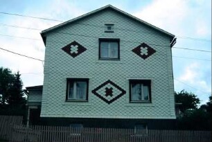 Giebelseite eines Hauses mit weißen Schindeln