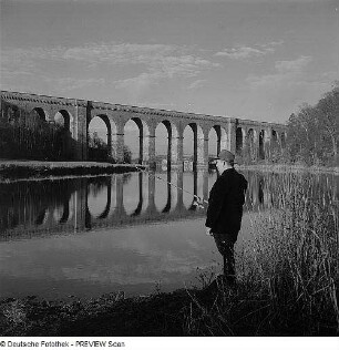 Angler, im Hintergrund eine Brücke