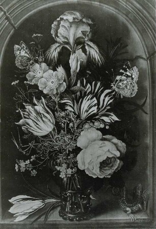 Blumen in grünem Weinglase vor einer Nische