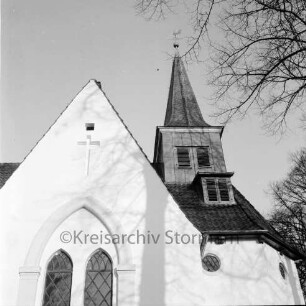 Matthias-Claudius-Kirche: Paul-von-Schoenaich-Straße: Außenaufnahme: nach Renovierung: Blick von Süden: Teilansicht: Turm und Giebel des seitlichen Anbaus: rechts oben überhängende Zweige eines Baumes