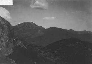 Gebirge : Blick über Gebirge. Am linken Bildrand Männer mit Lasttieren