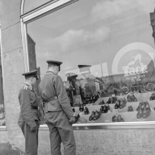 Wehrmachtssoldat in Uniform vor einem Schuhgeschäft, Soldaten auf Urlaub