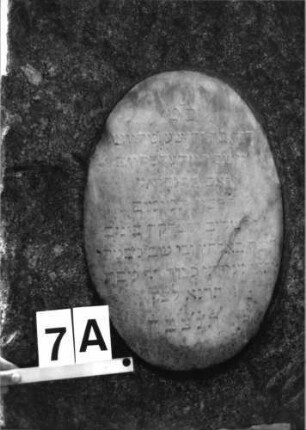 Grabstein 7 (Index: 100081786) Material: Granit, weiße Marmorplatten Zustand: Schriftplatten verwittert Maße HxBxT: 156x60x27 cm Beschreibung: konische Stele, gerader Abschluß, ovale und querrechteckige Schriftplatte: Grabstein 7A (1)