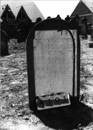 Grabstein 101 (Index: 99798128) Material: Sandstein Zustand: leicht verwittert Maße HxBxT: 92x56x11 cm Beschreibung: Stele, Rundbogenabschluß, Sockel: Grabstein 101A