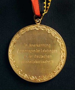 Goldmedaille Deutsche Meisterschaften in Kurzschrift und Maschinenschreiben in Rodalben 1984 am schwarz-rot-goldenen Band : Sammlung Deutscher Stenografenbund. Goldmedaille Deutsche Meisterschaften in Kurzschrift und Maschinenschreiben in Rodalben 1984 am schwarz-rot-goldenen Band. Messing; Durchmesser 50 mm, Gewicht 47,5 g (1984; Deschler & Sohn, München). Dresden: SLUB R c 0536