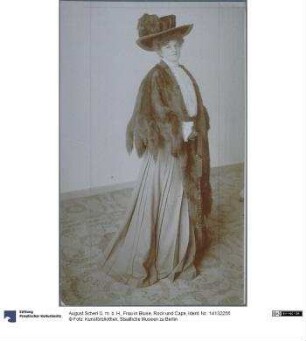 Frau in Bluse, Rock und Cape