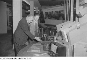 Besucher vor einem Messestand mit technischen Geräten