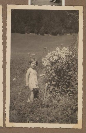 Christiane Zimmers Sohn Andreas steht im Kleidchen auf einer Wiese