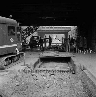 Pölitzer Weg: Bahnunterführung: Bau der Kanalisation: vorn zugeschüttete Baugrube: links Bagger: hinten Mitte Lkw, Arbeiter und Baumaterial: hinten rechts Fußgänger