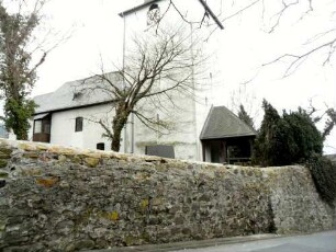 Ansicht von Nordwesten mit Kirche (Kirchturm querrechteckig-14 Jh) über Kirchhofmauer (Wehrgang mit Steinbrüstung im 18 Jh abgetragen)