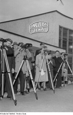 Besucher mit Ferngläsern und Fernrohren vor dem Ausstellungsgebäude von Carl Zeiss Jena