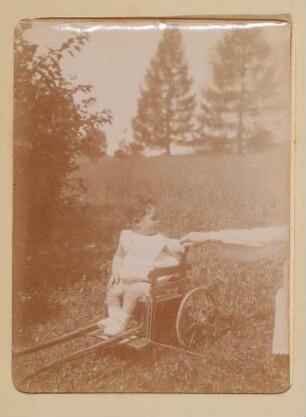Franz von Hofmannsthal als Baby in einer Kinderkutsche auf einer Wiese in Aussee