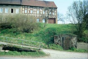 Straßenabschnitt mit Erdkeller am Hang, oben Bauernhaus, Scheune mit Torfahrt