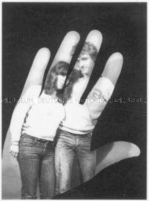 Menschliche Hand, in der ein junges Pärchen zu sehen ist (Altersgruppe 14-17)