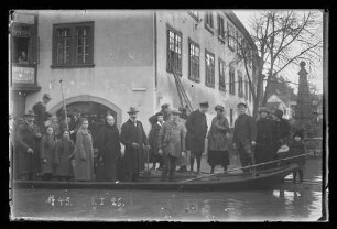 Hochwasser an der Ecke Brückengasse und Lindenstraße vor der Chorstift-Drogerie Schwender und Brunnen, Personen auf Schelch, darauf Nr. 45