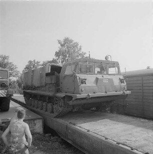 Verladen von Militärtechnik der 1. Gardepanzerarmee im Bf. Dresden-Klotzsche. Kettenschlepper fährt über Flachwagenzug