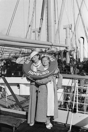 Reisefotos Spanien. Zwei Reisende mit Rettungsring an Deck des Passagierschiffes