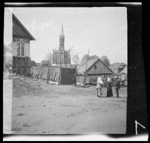 "Litauisches Dorf" mit Häusern an einer breiten Straße, im Hintergrund die Kirche
