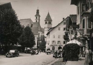 Kitzbühel. Tirol. Österreich. Ansicht der Vorderstadt mit Restaurant "Goldene Gams". Im Hintergrund die römisch-katholischen Stadtpfarrkirche "Zum Heiligen Andreas". Rechts daneben die gotische Liebfrauenkirche, deren Turm als Wahrzeichen der Stadt gilt