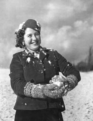 Winterbilder. Allgäu. Junge Frau während einer Schneeballschlacht