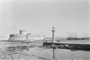 Hafeneinfahrt : Die Einfahrt zum Mandraki-Hafen von Rhodos. Im Hintergrund die Festung von Rhodos. Davor die Säulen mit den Statuen des Hirschpaares „Elafos und Elafina“.