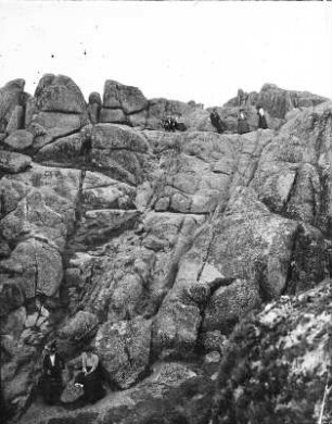 Felsformation : Markante Felsformation, vermutlich an einer Küste. Personengruppe an der Felswand
