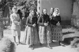 Frauen in Hoyerswerdaer Kirchgangstracht auf dem Heimweg vom Gottesdienst in Bluno. : Serbske kemšerki we Wojerowskej kemšacej drasće wote mšě w Blunju.