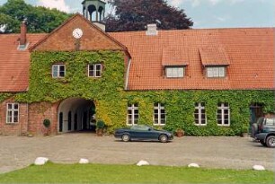 Altfresenburg: Gut: Torhaus, Teilansicht: Blick von Westen: Mittelteil mit Torduchfahrt, Zwerchhaus, in Giebel Uhr, darüber Dachreiter: Kletterpflanzen